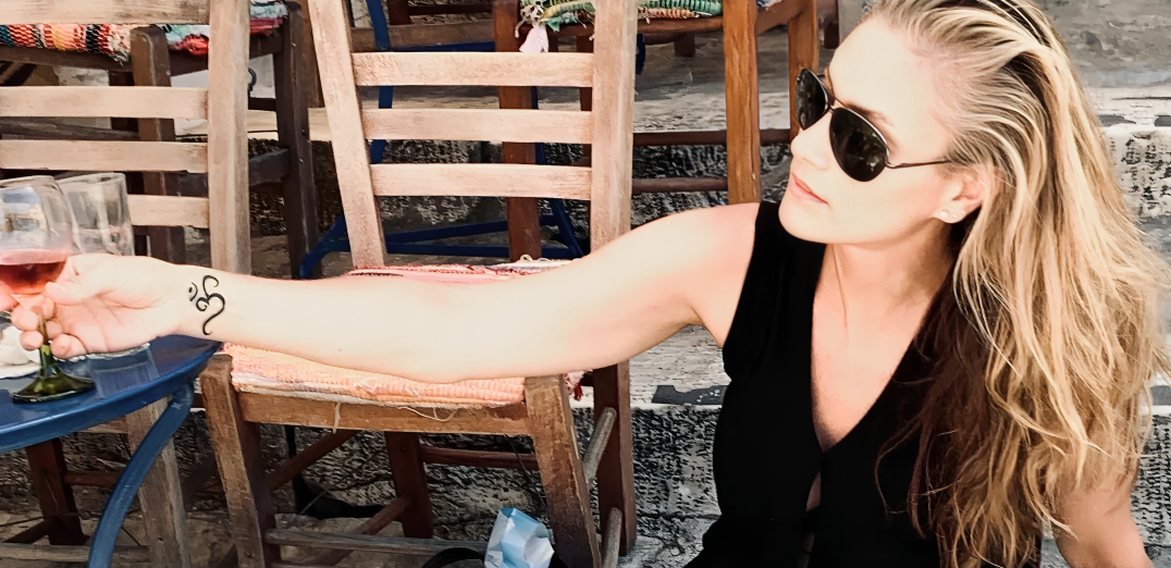 Woman with sunglasses holding a wine glass.