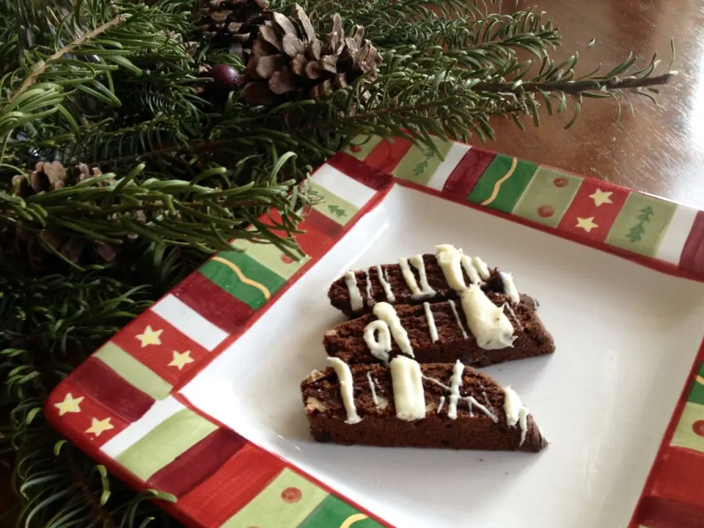 Festive chocolate brownies with white icing on a holiday-themed plate.
