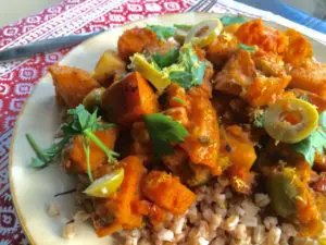 A vibrant plate of curry with vegetables and rice.