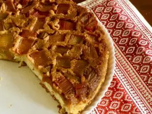 A slice of homemade lattice apple pie on a patterned cloth.