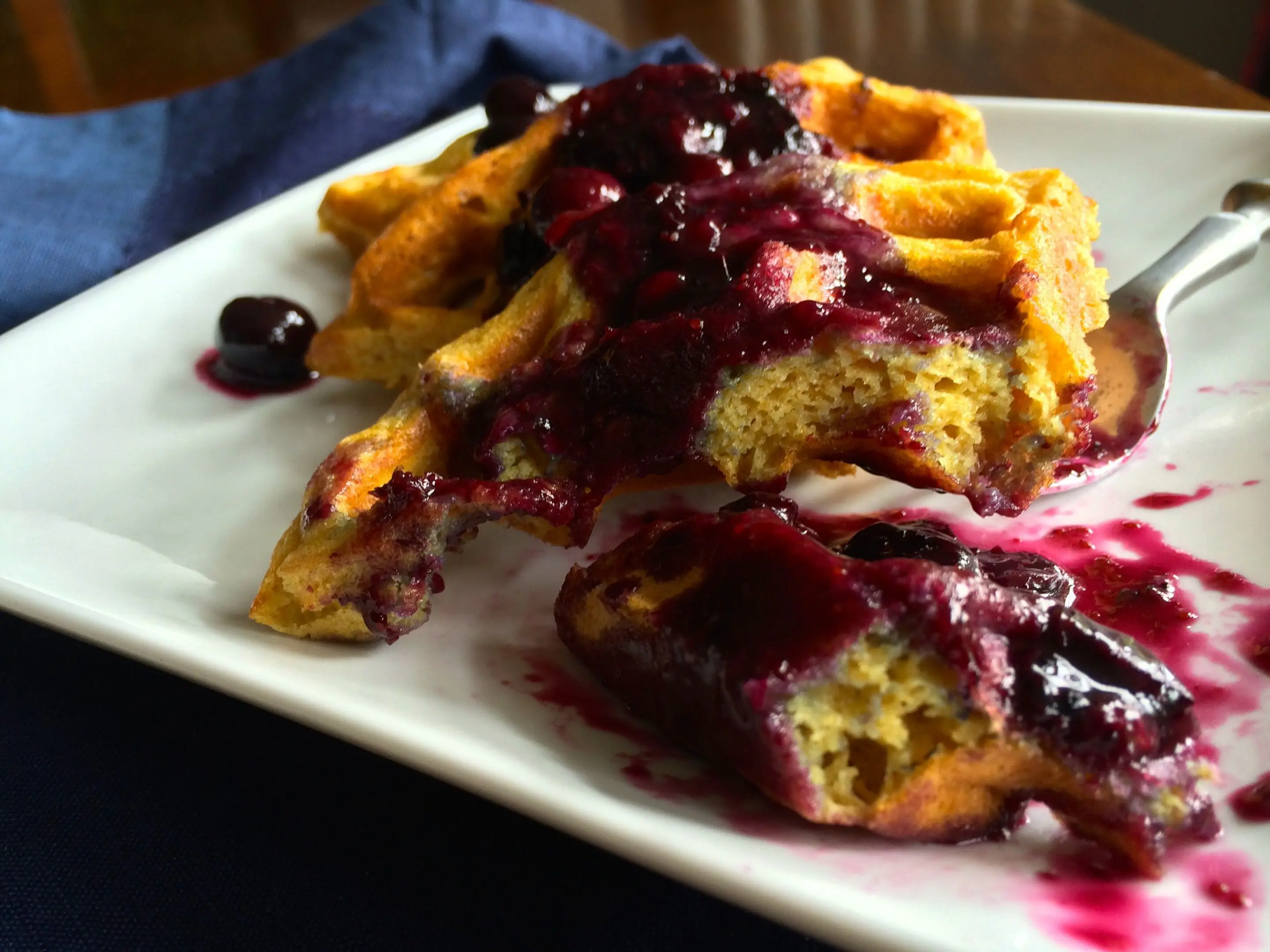 French toast topped with berry compote on a white plate.