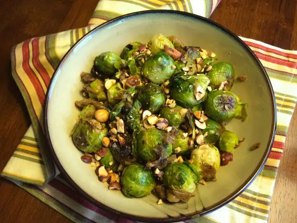 A bowl of roasted Brussels sprouts with chickpeas and nuts.