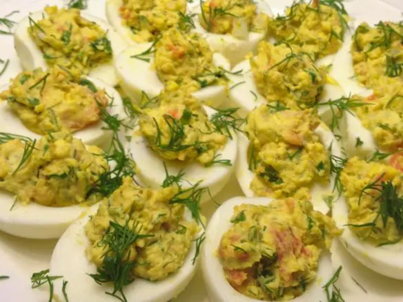 Close-up of deviled eggs with herbs and spices.
