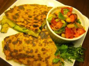 Golden-brown quesadilla served with fresh tomato and cucumber salad.