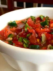 A bowl of fresh tomato salsa with herbs.
