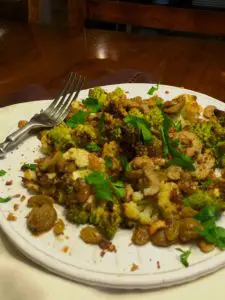 A plate of seasoned, cooked chickpeas garnished with herbs.
