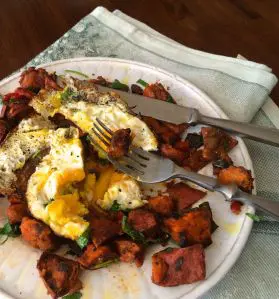 A plate with a poached egg and roasted vegetables.