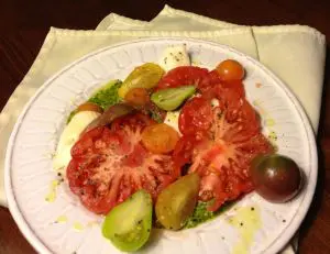 Plate with sliced heirloom tomatoes and avocado pieces.
