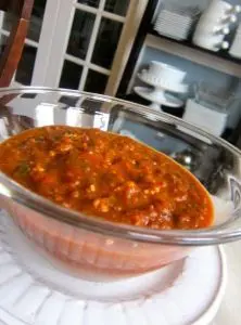A bowl of rich tomato-based stew with herbs and spices.