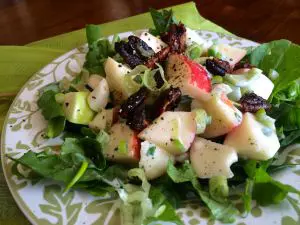 Fresh mixed green salad with apples and red onions.