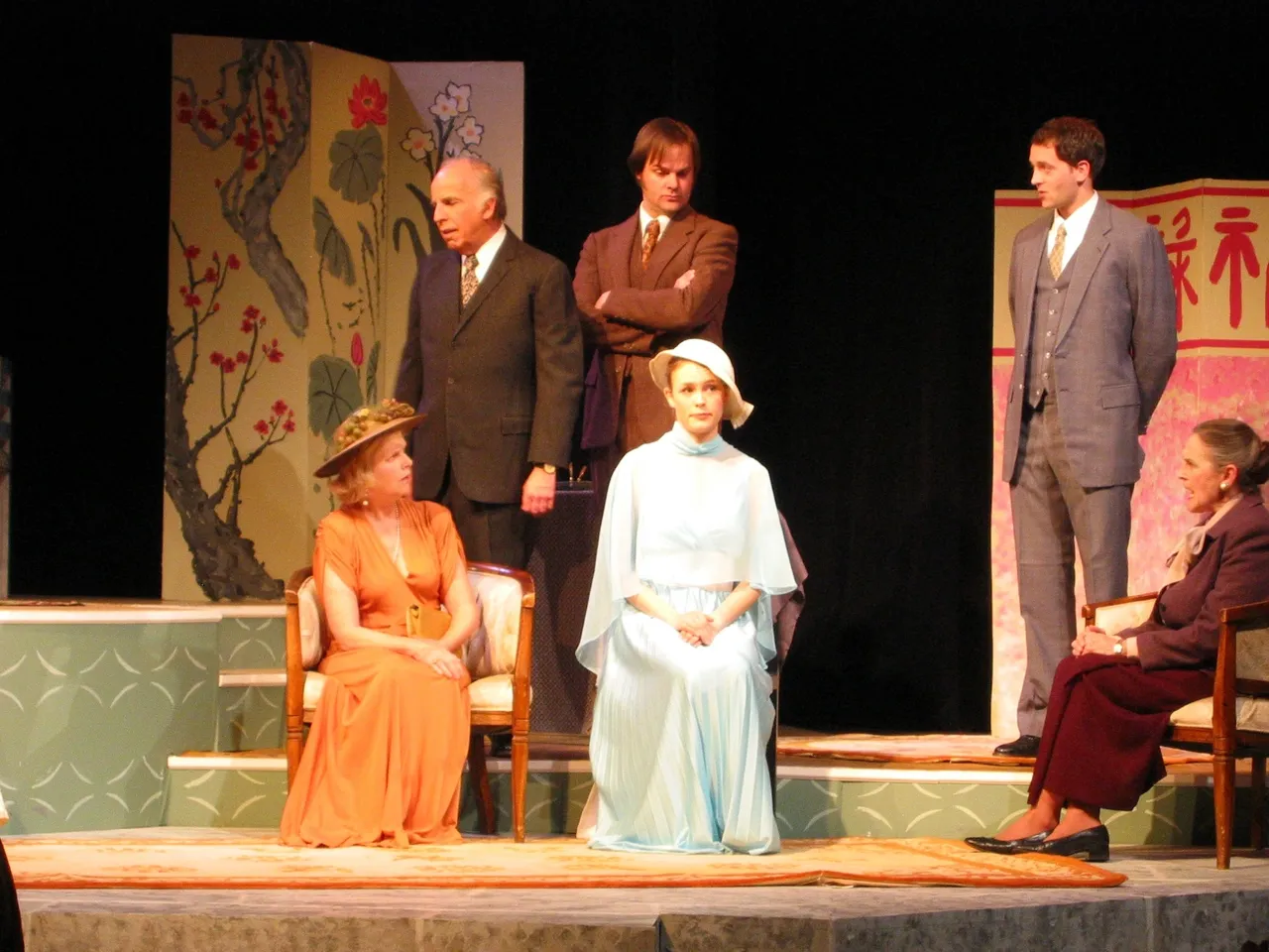 Actors performing a dramatic stage play in period costumes.