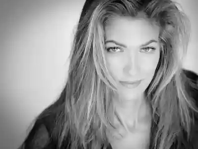 Black and white portrait of a woman with long hair and a subtle smile.