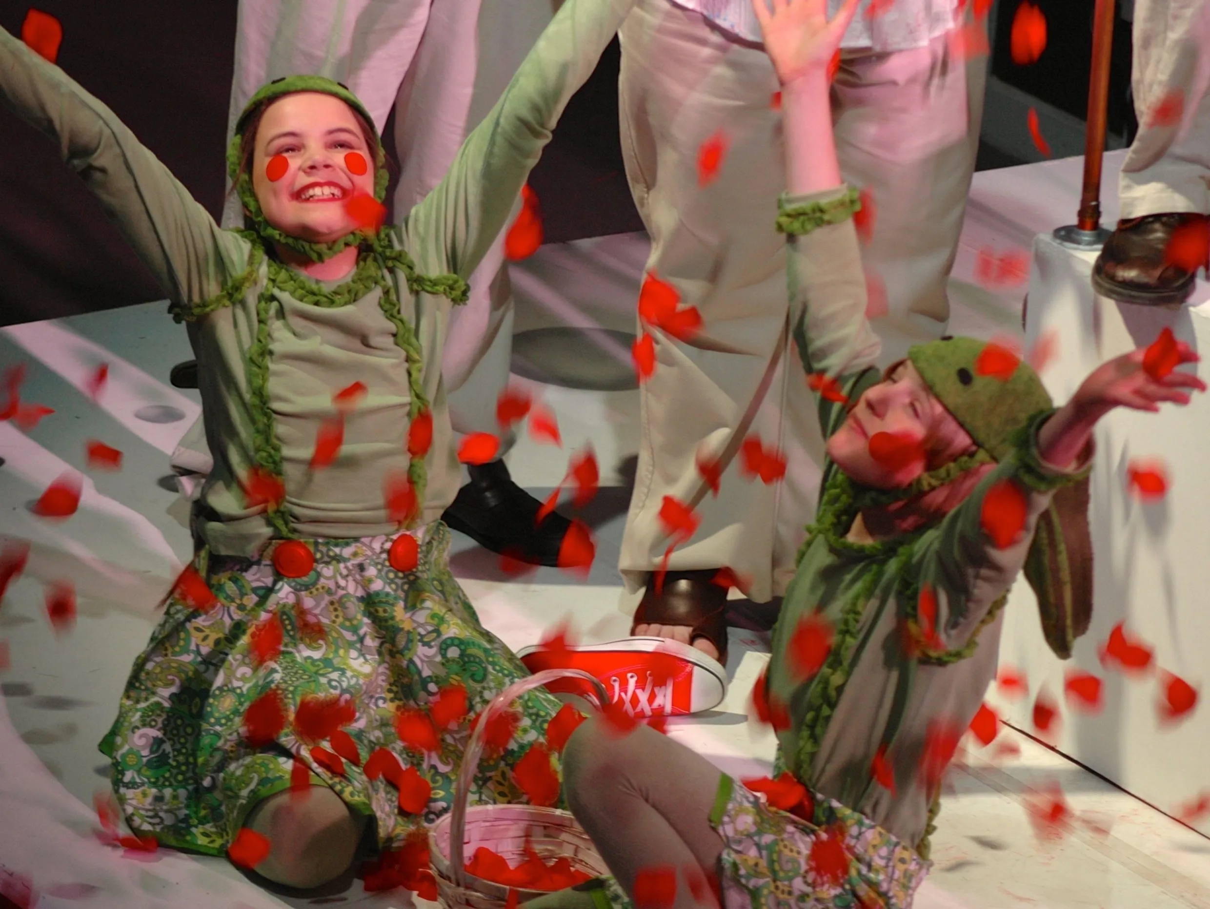 Two dancers in floral costumes perform with expressive joy and grace.