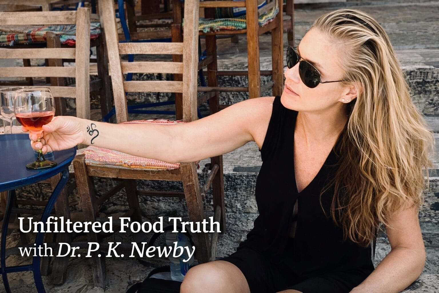 Dr. P.K. Newby seated outdoors with a glass of rosé. Unfiltered Food Truth with Dr. P.K. Newby.
