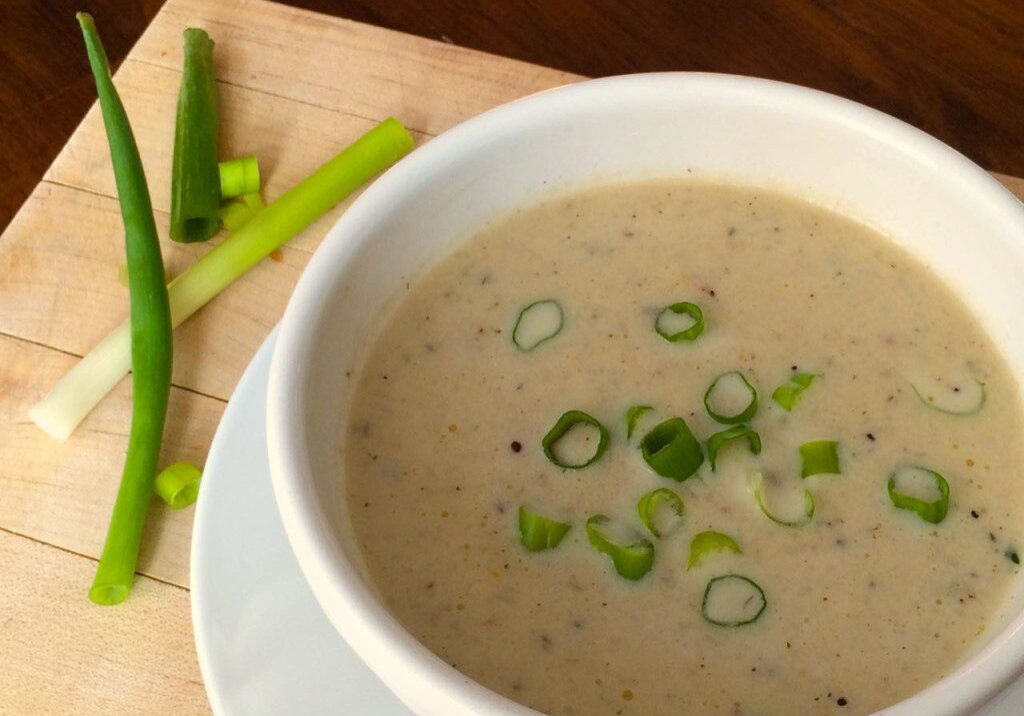 Creamy mushroom soup garnished with chopped green onions.
