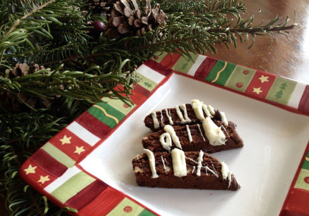 Festive chocolate brownies with white icing on a holiday-themed plate.