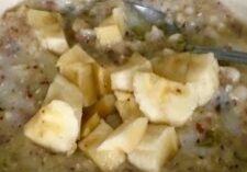 A bowl of oatmeal topped with chopped bananas.