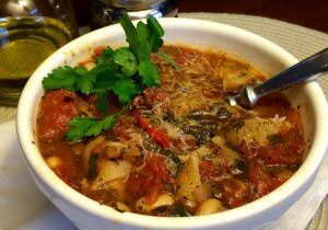 A bowl of spicy tomato soup garnished with fresh cilantro.