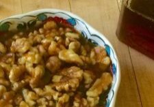 Bowl of shelled walnuts on a wooden table.