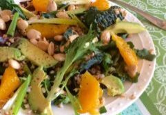 A colorful mixed vegetable salad with greens and seeds.