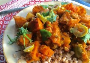 A vibrant plate of curry with vegetables and rice.