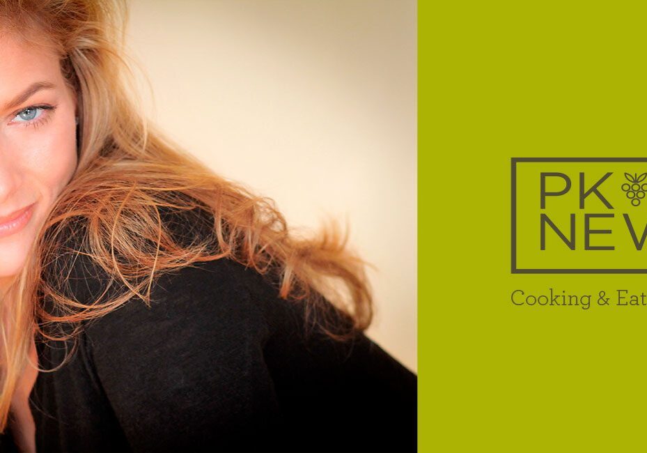 Partial view of a woman with red hair against a beige background.