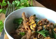 Bowl of noodles with vegetables and nuts.