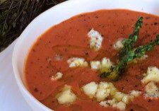 Creamy tomato soup garnished with herbs and cheese.