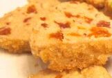 Close-up of crumbly baked squares with visible bits of fruit or nuts.