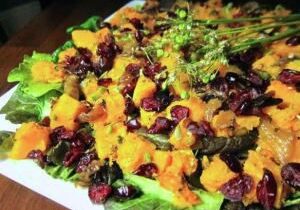 Colorful salad with cranberries and dressing on lettuce.