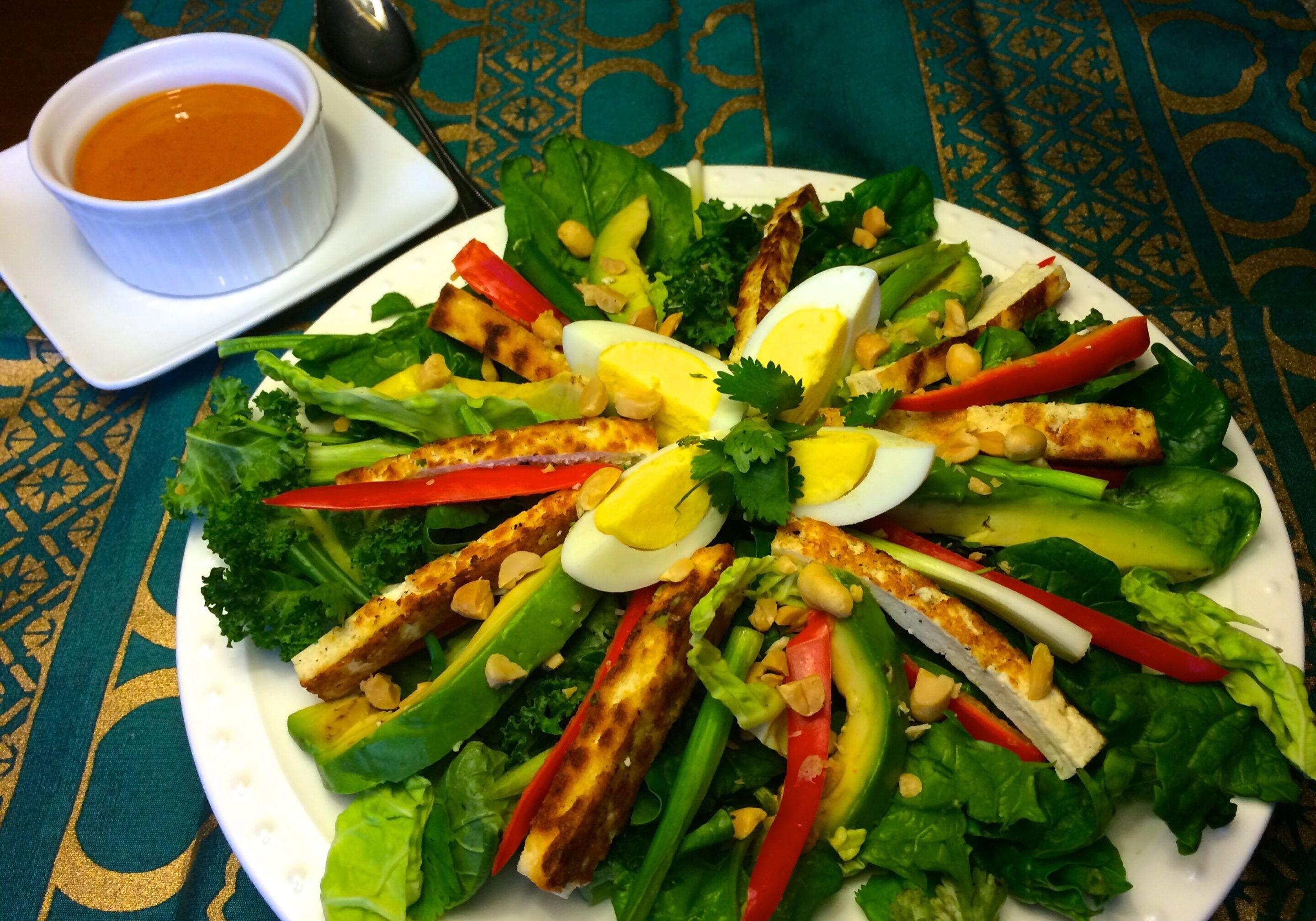 A colorful salad with greens, boiled egg, and assorted vegetables.