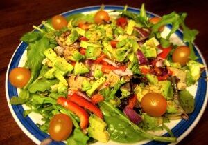 Fresh mixed salad with cherry tomatoes, carrots, and avocado.