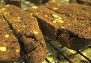 Close-up of freshly baked chocolate biscotti with nuts on a cooling rack.