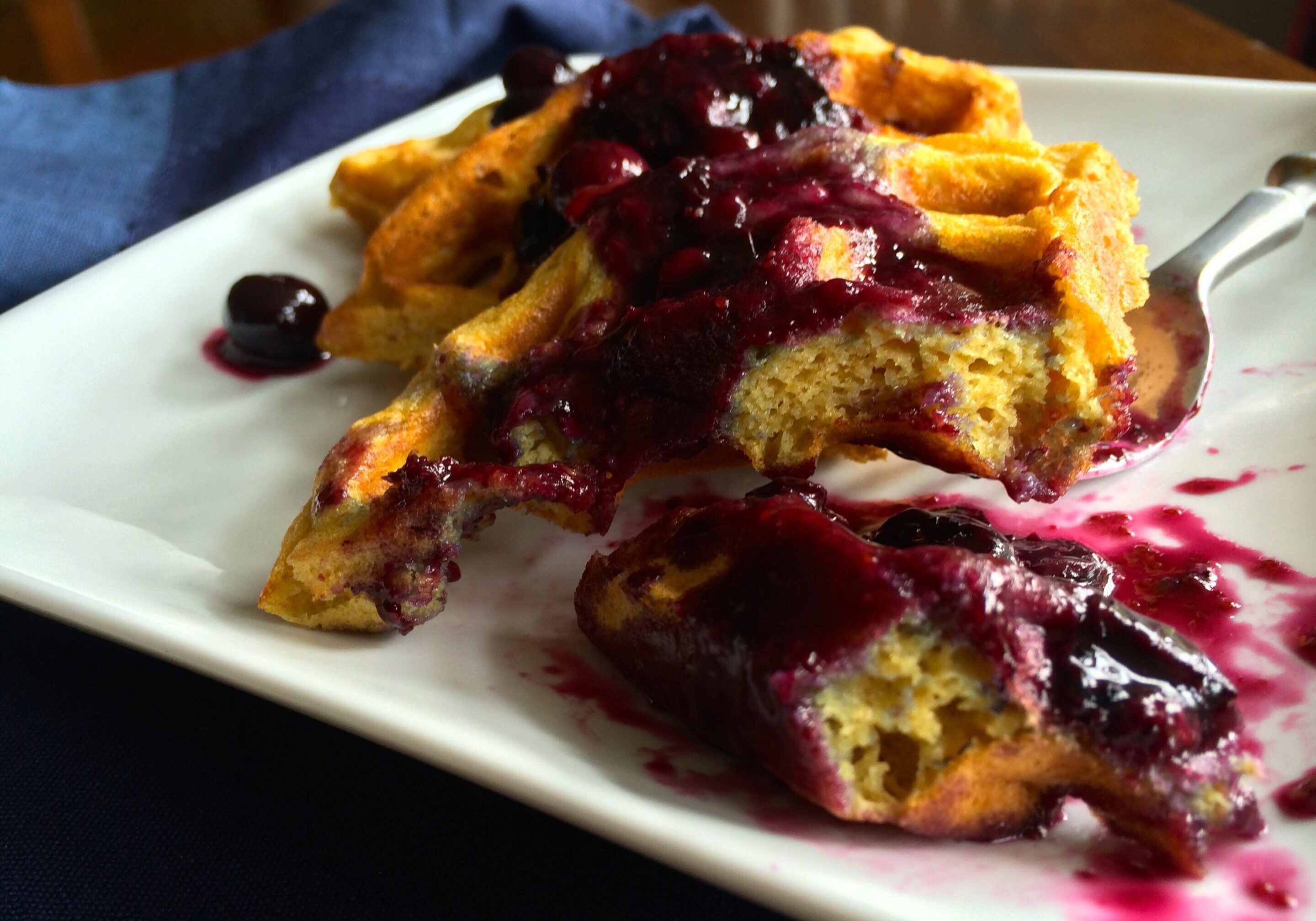 French toast topped with berry compote on a white plate.