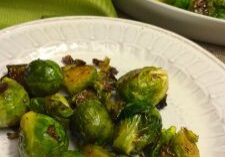 A close-up of roasted Brussels sprouts on a white plate.