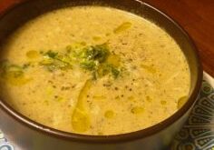Creamy soup garnished with herbs and lemon zest in a bowl.