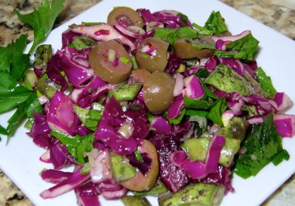 Fresh salad with purple cabbage, olives, and green vegetables.