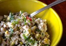 A bowl of mixed salad with veggies and grains.