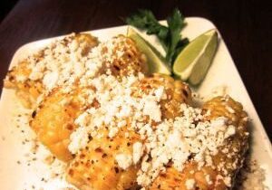 Delicious grilled chicken topped with crumbled cheese and garnished with lime and herbs.