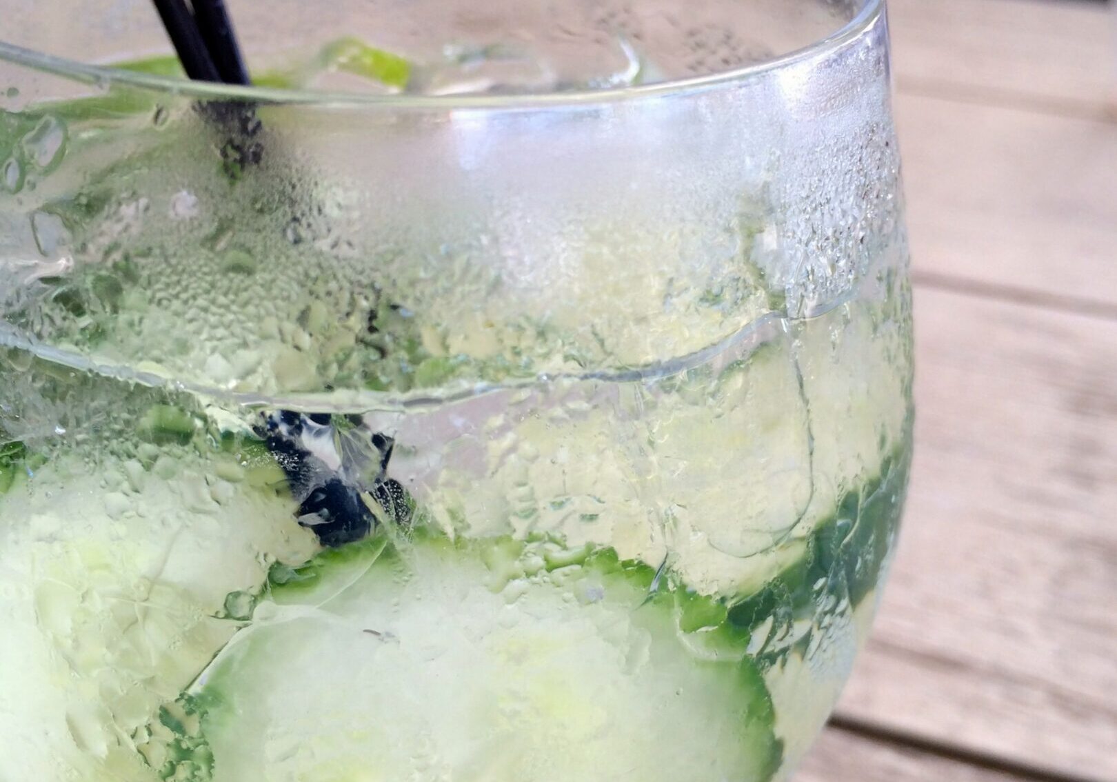 Refreshing cucumber-infused drink with ice in a clear glass.