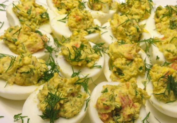 Close-up of deviled eggs with herbs and spices.