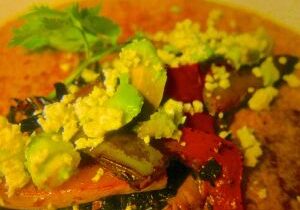 Close-up of a colorful vegetable dish with avocado and scrambled eggs.
