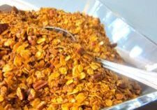 A bowl of crunchy cereal with a spoon.