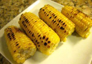 Grilled corn on the cob with char marks.