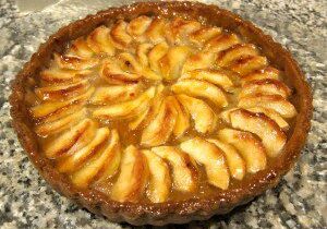 A freshly baked apple tart with golden brown crust and caramelized apple slices.