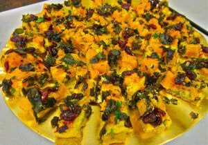 A plate of savory, colorful vegetable and paneer stuffed snacks.