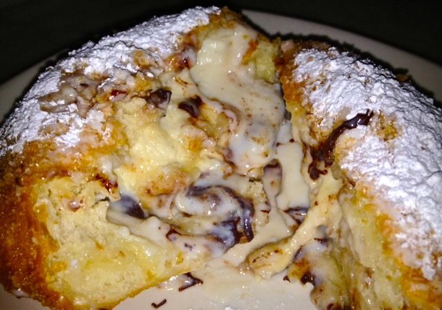 Close-up of a creamy chocolate-filled pastry dusted with powdered sugar.