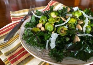 Fresh kale salad with chickpeas and cheese in a glass bowl.
