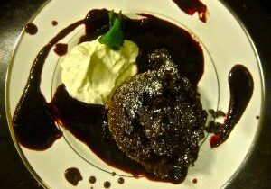 Chocolate lava cake with vanilla ice cream and berry sauce.