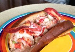 Lobster roll served on a colorful plate.